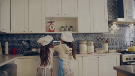 两个小女孩在厨房里刷碗