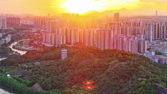 惠州大亚湾夕阳下的城市高楼与山林景观