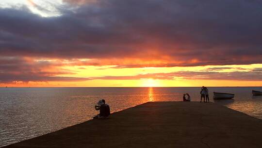 海边夕阳情侣在拍照