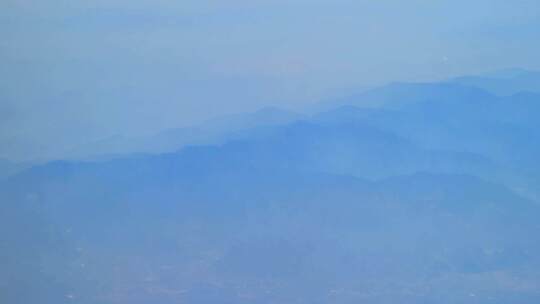 飞机窗外云雾缭绕重峦叠嶂的山峦