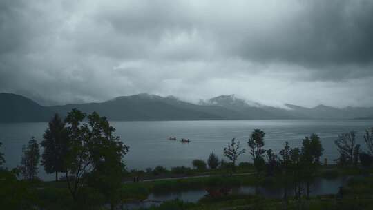 云南高原湖泊泸沽湖阴雨天乌云山脉湿地公园