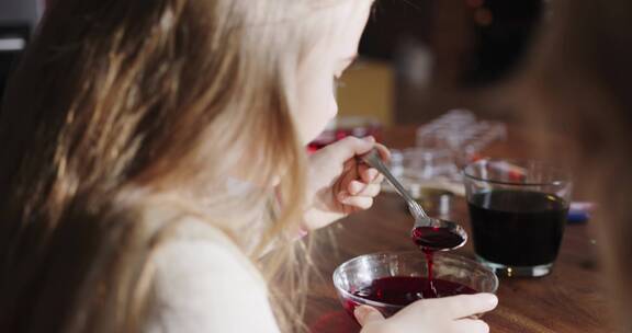 女孩搅拌一碗红色着色剂