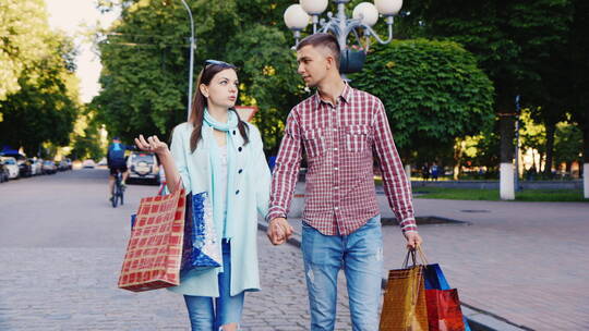 年轻夫妇手拉手走在大街上视频素材模板下载