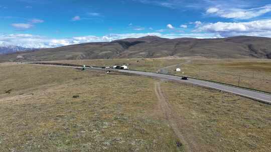 秋季航拍汽车行驶在四川甘孜高山草原上