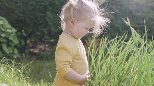小女孩看着脚下的草坪