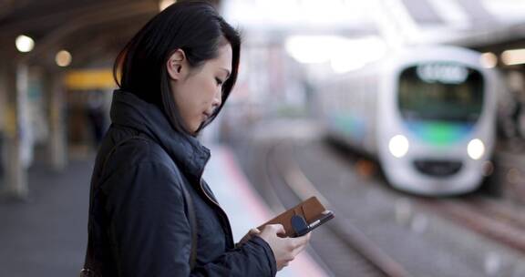 女人在火车站候车时玩手机