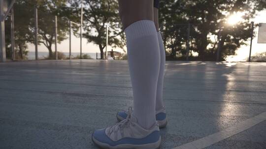 清晨女篮球运动员在运动场喝水