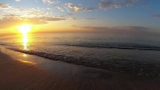夕阳下的海岸线波浪徐徐拍打沙滩