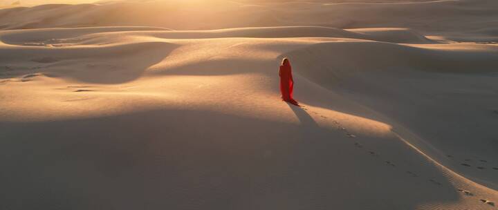 沙漠中行走的红衣女子