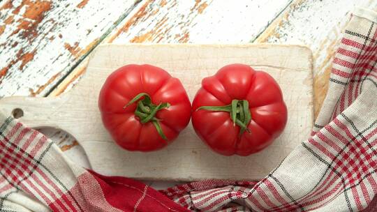 两个新鲜的生态番茄放在白色木制砧板上视频素材模板下载