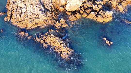 空中俯瞰岩石海岸边的碧绿海水