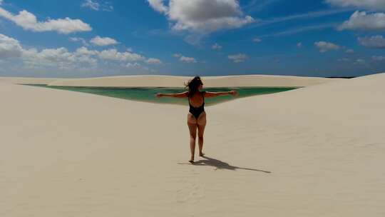 穿泳装在沙地行走的女人