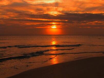 日落时海滩上翻滚的海浪