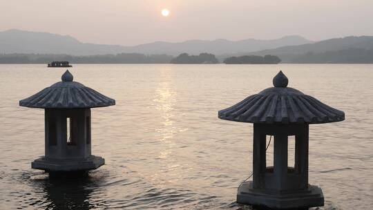 夕阳下波光粼粼的西湖和灯塔