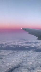 从飞机窗口观看粉色晚霞天空城市傍晚