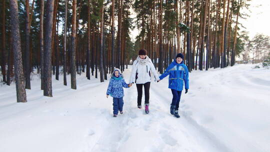 妈妈和孩子们在雪地里嬉戏散步