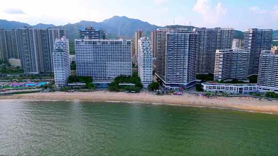 海滨城市高楼边的沙滩和海水景象