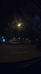 从汽车内部看深夜城市的街道与路灯