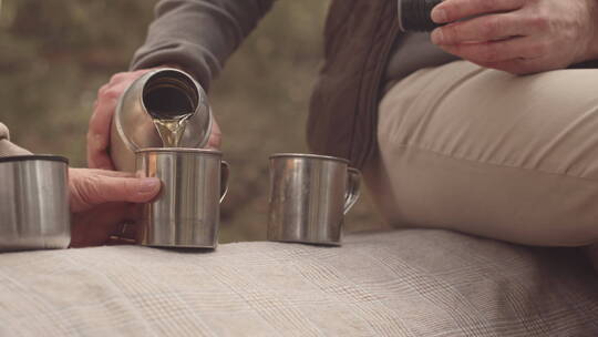 在森林里用保温杯喝茶