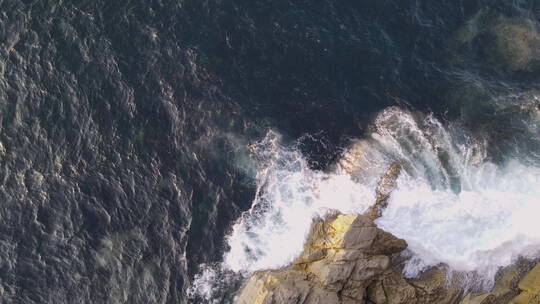 海浪冲破岩石海岸的鸟瞰图视频素材模板下载