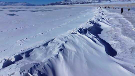 航拍新疆冬季赛里木湖冰封湖面雪山冰湖积雪