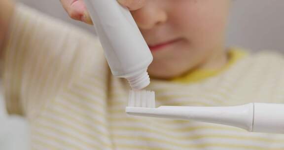 儿童在牙刷上涂抹牙膏
