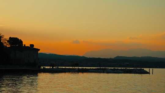 金色的日落在湖上，平静的水慢慢移动，橙色的天空。放松的情感时刻。