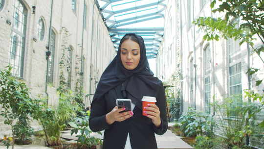 头巾中间年轻自信的穆斯林女商人拿着智能手视频素材模板下载