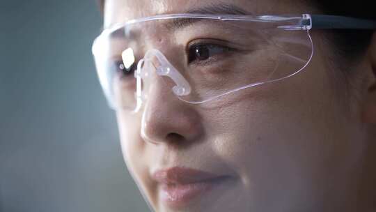 女性科研人员戴着护目镜在生物实验室做实验