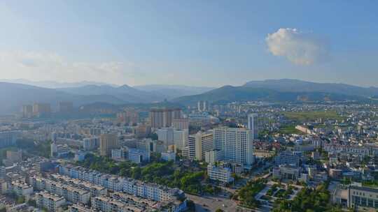 傍晚时分夕阳照耀下的大理祥云城市逆光航拍