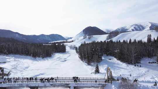 航拍新疆禾木雪景森林雪地小木屋禾木桥雪山