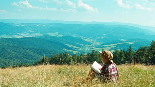女孩坐在山顶上读书