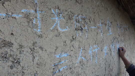 山区儿童在墙上写字
