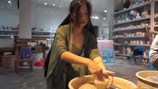 美女游客体验制作陶瓷手工艺术品瓷器碗拉坯视频素材模板下载