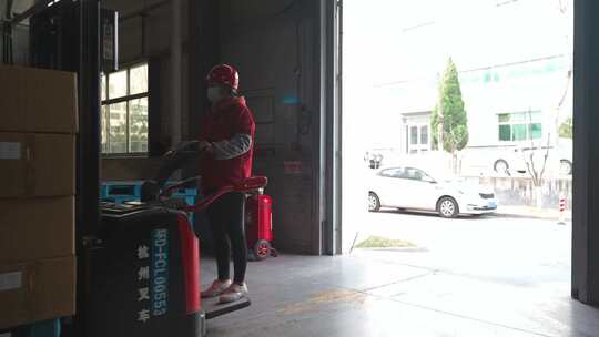 仓库工人操作叉车搬运货物