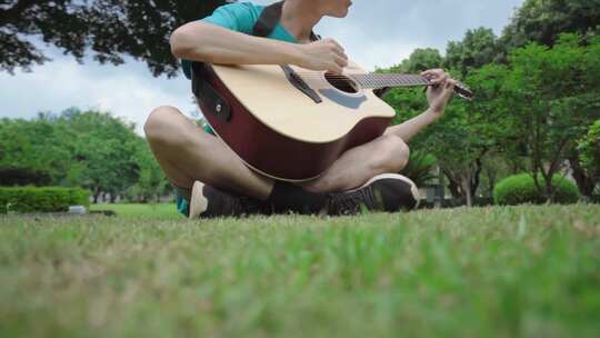 草坪弹吉他男生慢动作