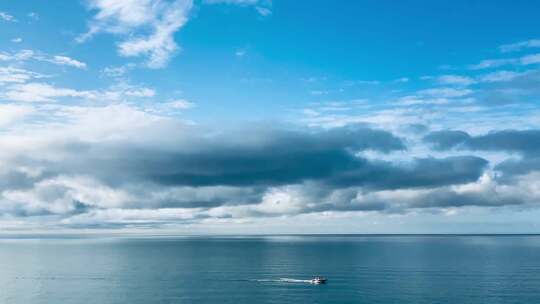 广阔海面之上多云天空下的船只