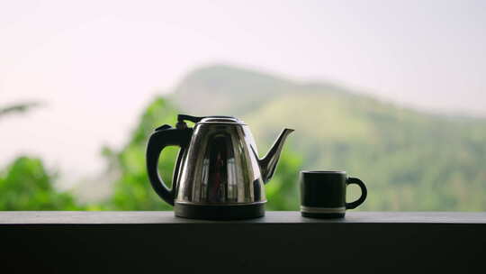 栏杆上的不锈钢茶壶杯茶时间风景山脉背景相