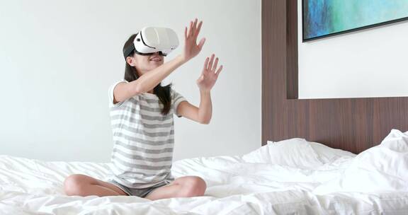女人坐在床上戴着虚拟眼镜