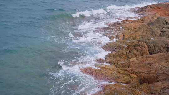 海边蓝色的海浪冲击礁石