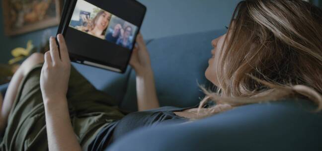 女人正躺在床上和朋友视频聊天