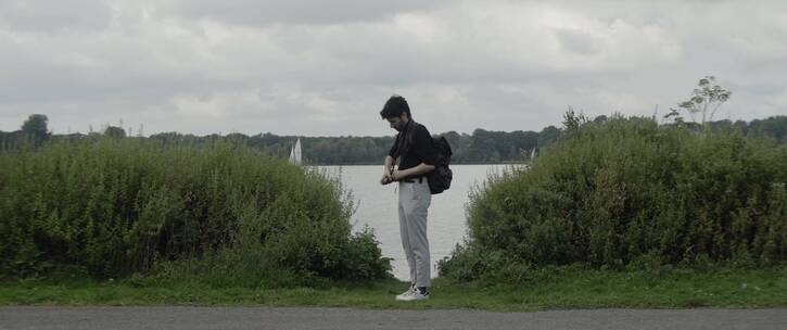 男人站在湖边拍摄美景