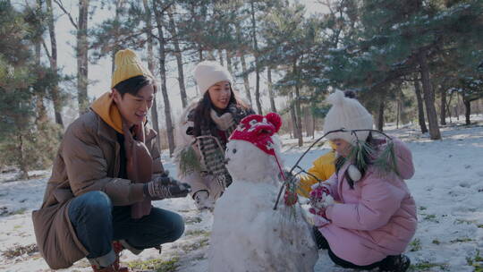 快乐家庭在雪地里堆雪人