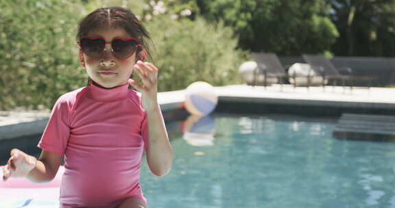 棕色头发的出生女孩穿着粉色泳衣和心形太阳