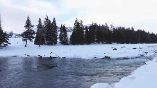 航拍新疆冬季喀纳斯湖雪景雪山森林冰河晨雾