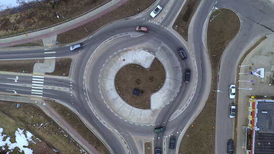 当机动车辆进出环形交叉路口时，空中仍然拍摄了在环形交叉路口上方盘旋的照片