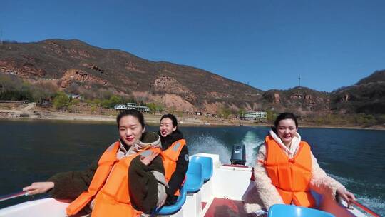 湖面上三个女孩坐着游艇
