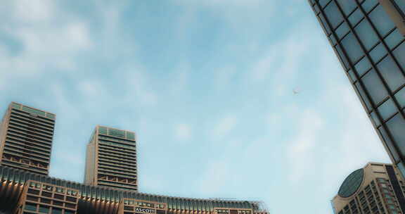 蔚蓝天空下飞机飞过重庆市来福士大厦的上空