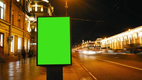 傍晚街道上有绿屏的广告牌