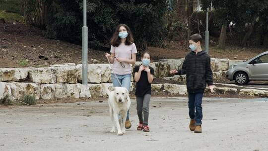 儿童牵着狗狗在大街上散步
